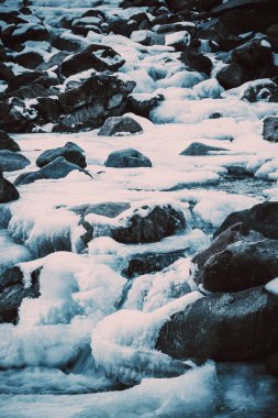 Kış dağ nehri buz altında. Su buz ve buz sarkıtları döndü.
