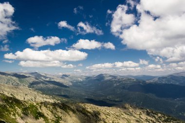 Taşların altında mavi gökyüzü bulutlu. Dağ vadinin görünümü. Turizm, seyahat dağlar.