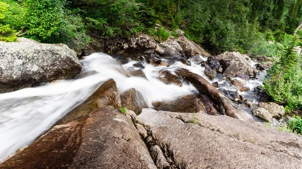 Vertical waterfall in rocks. Mountain river in mountains.