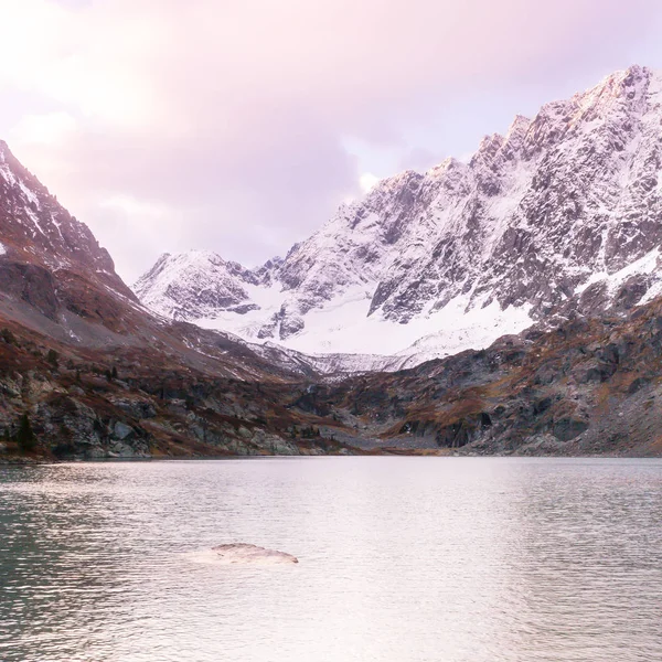 Mountain lake in winter. Dawn in rocks. Travel in mountain valley along river