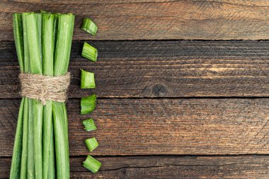 Masada bir sürü yeşil soğan var. Mutfakta salata yapmak için dilimlenmiş soğan.