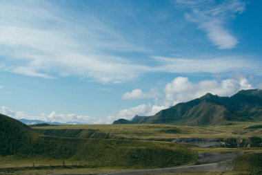 Mavi gökyüzünün altında bulutlu kayalar. Dağ yürüyüşü, yaz turizmi.