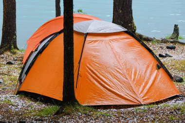 Dağ gölünün kıyısında turist çadırı. Ormanda yürüyüş, seyahat için turistik ekipman