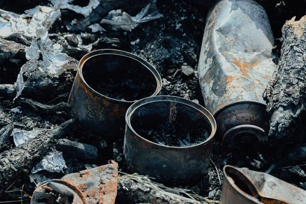 Iron cans burned in fire. Bad ecology, pollution of environment. Nature protection.