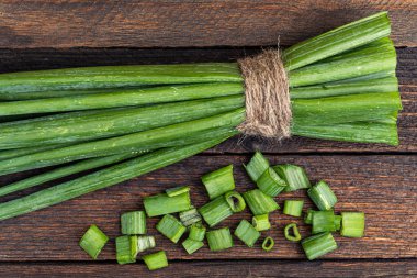 Masada bir sürü yeşil soğan var. Mutfakta salata yapmak için dilimlenmiş soğan.