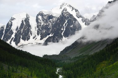 Mavi gökyüzünün altında bulutlu kayalar. Dağ yürüyüşü, yaz turizmi.