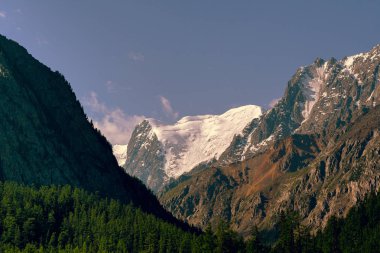 Mavi gökyüzünün altındaki kar kayalıkları. Dağlarda seyahat et.