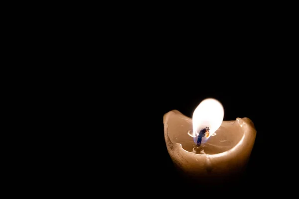 lonely memorial candle. Candle flame burns in dark