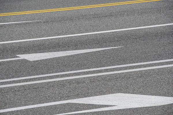 grey asphalt road with markings for drivers, traveling by car