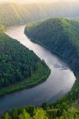 wide river between green hills, smooth bend of riverbed, contemplation of nature for meditation and relaxation