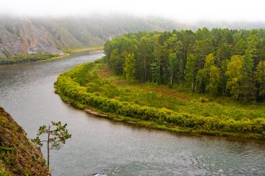 Kayalar ve ormanlar arasında nehir akışı, rezervuarın kıyısındaki ağaçlar, sonbaharın başlarında dağ vadisinde seyahat ederler.