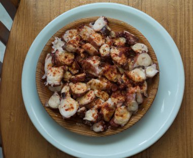 Kırmızı biber ve zeytinyağı ile pişirilmiş ahtapot Galiçyaca tarzı ahşap tabak.