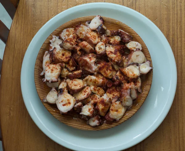 Kırmızı biber ve zeytinyağı ile pişirilmiş ahtapot Galiçyaca tarzı ahşap tabak.