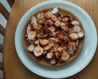 Kırmızı biber ve zeytinyağı ile pişirilmiş ahtapot Galiçyaca tarzı ahşap tabak.