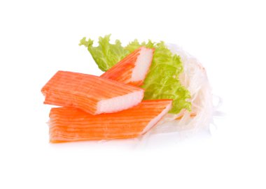 Yengeç sopalarla marul ve beyaz zemin üzerine dilimlenmiş turp