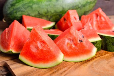 Bütün ve bölümü ahşap kesme tahtası üzerinde karpuz kesmek 