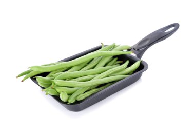 Beyaz arka planda siyah tavada taze Fransızca fasulye
