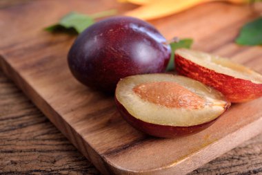 tam ve yarı ahşap arka plan üzerinde taze erik kesmek