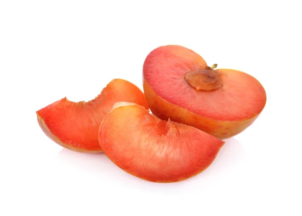 yarısı ve taze pluot beyaz zemin üzerine dilimlenmiş