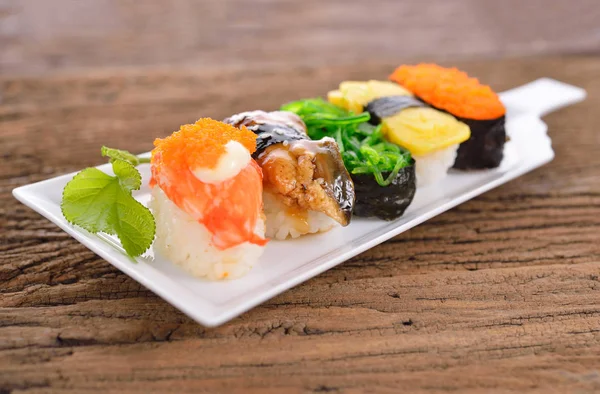 Suşi Seti nigiri ve sashimi odunsu uzun beyaz tabakta servis