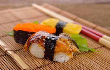 Suşi nigiri ve sashimi üzerinde çubuklar ile bambu mat servis