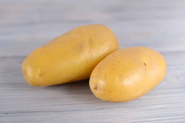 Unpeeled fresh potato on wooden gray background — Stock Photo, Image