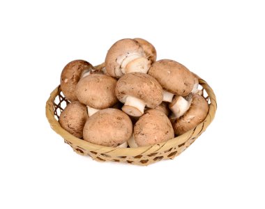 Beyaz arka planda bambu sepetinde taze şampiyon mantarı.