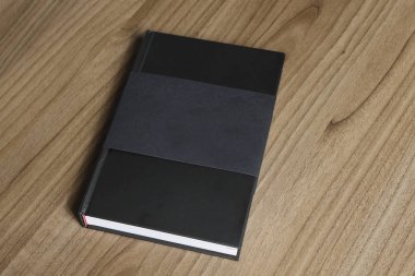 Ciltli kara kitap kapak koruyucu düz ahşap yüzey - siyah mock-up kitap - tarih ile masaya kitaptır