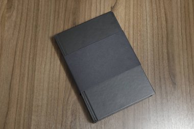 Ciltli kara kitap kapak koruyucu düz ahşap yüzey - siyah mock-up kitap - tarih ile masaya kitaptır