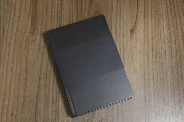 精装黑色书与封面保护在平木表面 黑色模型书 书在桌上 — 图库照片