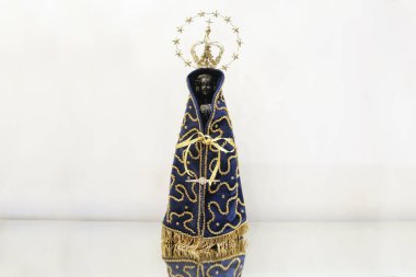 Statue of the image of Our Lady of Aparecida, mother of God in the Catholic religion, patroness of Brazil, isolated, with alliances, in a neutral background environment clipart