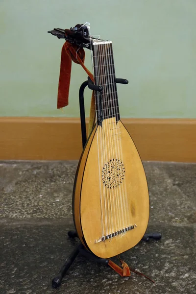 Musical instrument of wood and rope lute alaude alight in instrument stand