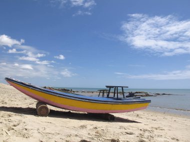mavi ve sarı renk, mavi gökyüzü ve tipik bir ışık gün - seyahat ve tatil kavramı - Fortaleza Coast, Ceara, Brezilya ile beyaz plaj üzerinde eski bir ahşap tekne ile tropikal peyzaj