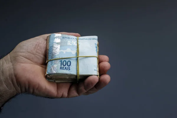 Hands holding Brazilian real notes - Money from Brazil - Notes o