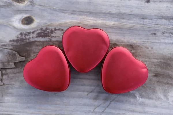Tin hearts - Three tin hearts on wooden surface
