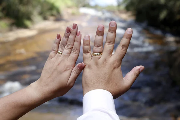 Mãos unidas e alianças de casamento — Fotografia de Stock