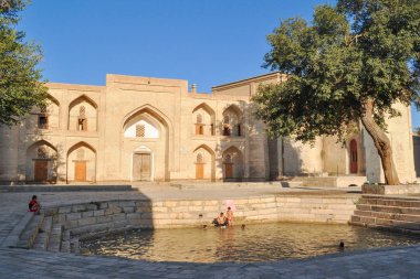 Çocuklar Buhara, Özbekistan gün batımında bir göletyüzmek.