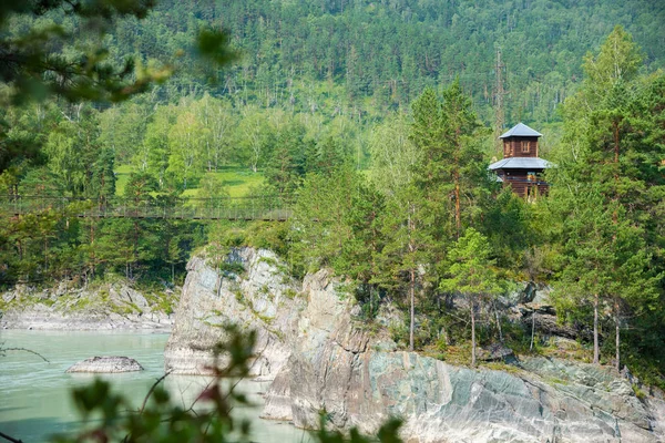Patmos adasında Ortodoks ahşap Kilisesi, Katun nehri üzerinde asma köprü, Altay, Rusya.