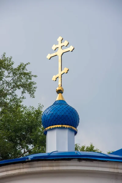 Hıristiyan Kilisesi'nin mavi kubbeli altın haçı. Tomsk'taki Holy Trinity Kilisesi, Rusya.