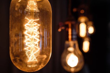 Lamba akkor sarmal retro vintage sıcak tüp edison. Spiral tavana, ilginç şekil üzerinde asılı sarı ışık, karanlık arka plan,.