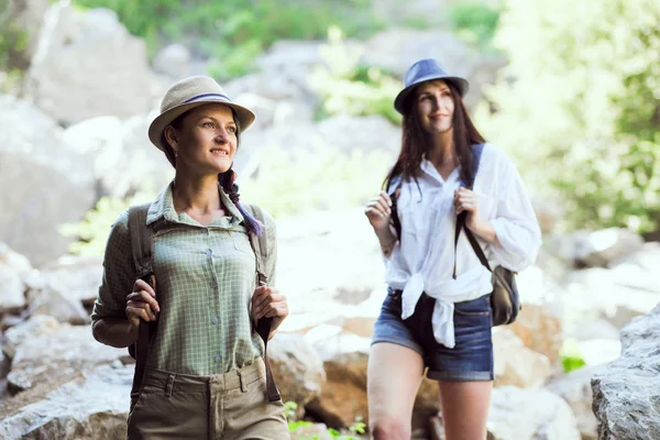 Twee mooie jonge meisjes reizen in de bergen en geniet van het Uitzicht van het landschap van stenen. — Stockfoto