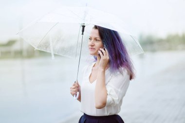 Kadın konuşmak için şemsiye ile cep telefonu
