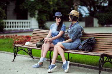 iki güzel genç kadın parkta bir bankta oturan