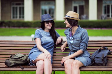 iki güzel genç kadın parkta bir bankta oturan