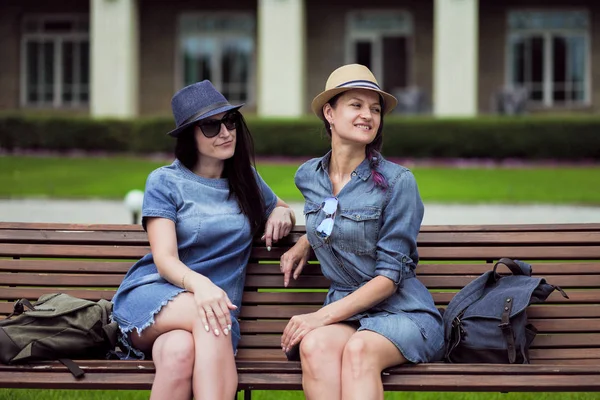 iki güzel genç kadın parkta bir bankta oturan