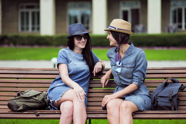 iki güzel genç kadın parkta bir bankta oturan