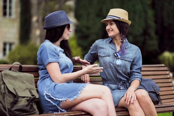 iki güzel genç kadın parkta bir bankta oturan