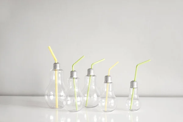 Fünf Gläser für Getränke in Form von Glühbirnen mit farbigen Röhren. — Stockfoto