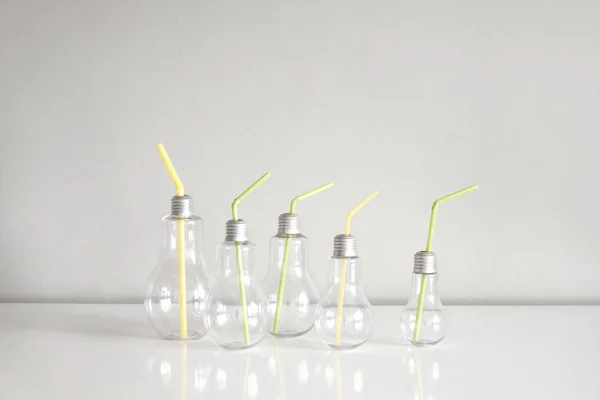 Fünf Gläser für Getränke in Form von Glühbirnen mit farbigen Röhren. — Stockfoto