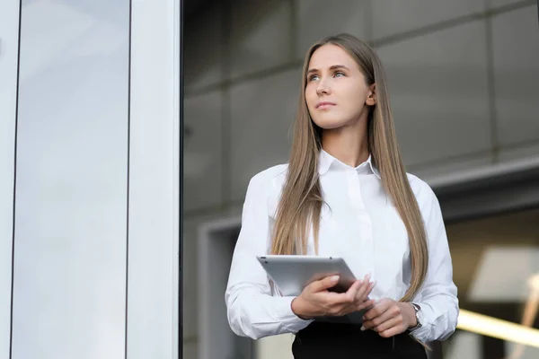 Mooi meisje maakt gebruik van Tablet PC op kantoor met glazen wanden. — Stockfoto